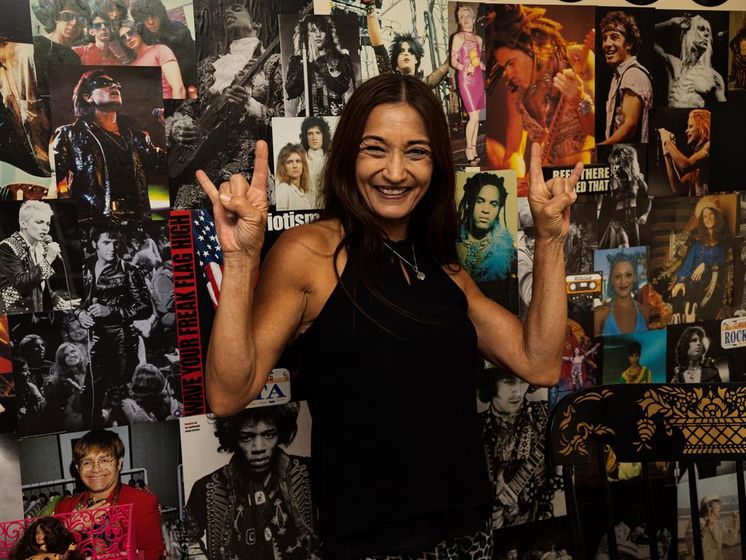 Kucirek poses in front of a backdrop in her home studio where she films content for social media.